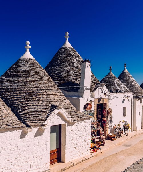 Houses of the tourist and famous Italian city of Alberobello, with its typical white walls and trulli conical roofs.